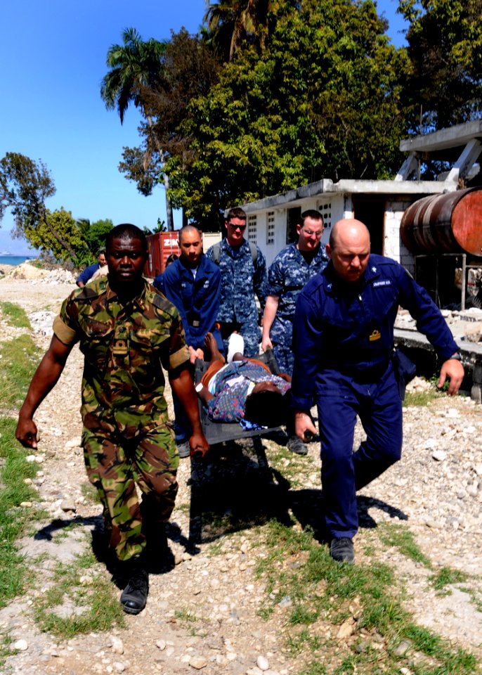 US Navy 100129-N-6676S-007 Sailors carry an injured Haitian woman to the landing zone at the Killick Haitian Coast Guard Base to be airlifted to a nearby treatment facility