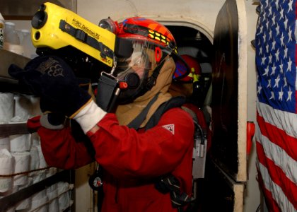 US Navy 100128-N-6692A-047 Damage Controlman Fireman Matthew Barrera uses a Naval Firefighting Thermal Imager to locate hot simulated spots during damage control training