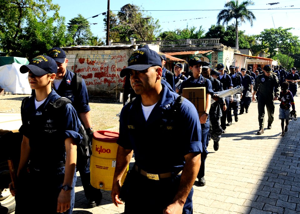 US Navy 100128-N-8655E-086 Sailors assigned to the multi-purpose amphibious assault ship USS Bataan (LHD 5) walk through the town of Grand Goave, Haiti to remove rubble, salvage materials and distribute food to Haitian citizens