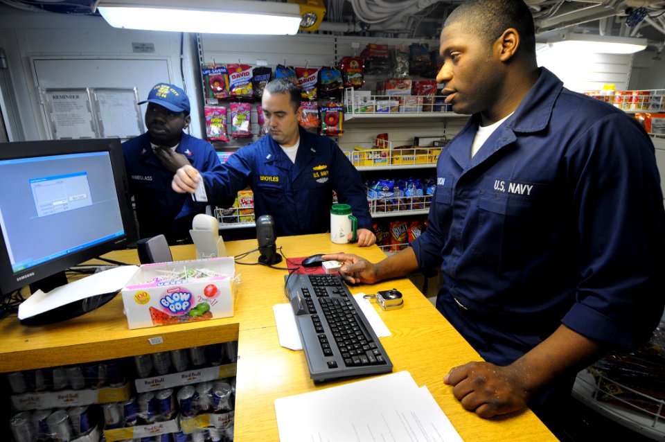 US Navy 100130-N-1688B-129 Storekeeper Seaman William Selmon helps customers with purchases in the ship's store aboard the guided-missile cruiser USS Hue City (CG 66)