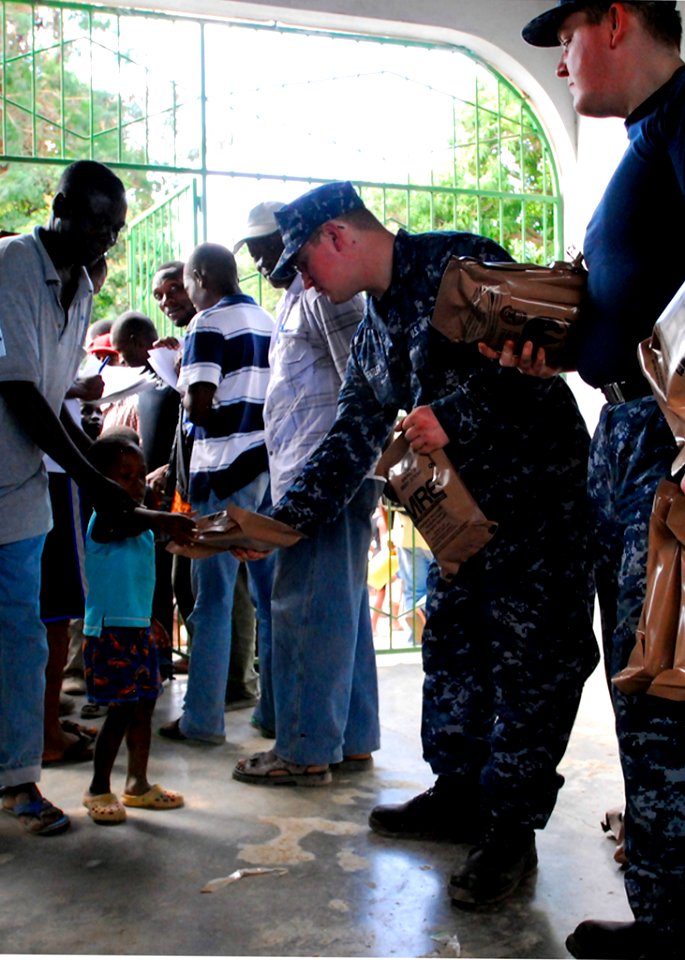 US Navy 100130-N-5244H-058 A Haitian boy receives a meal-ready-to-eat (MRE) from Sailors assigned to the dock-landing ship USS Carter Hall (LSD 50) at a Birey, Haiti school