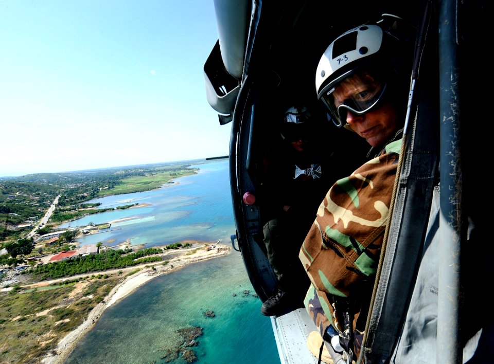 US Navy 100128-N-5345W-072 Rear Adm. Patricia Wolfe looks out from an MH-60S Sea Hawk helicopter while flying over the Haiti coastline en route to Port-au-Prince
