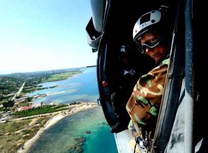 US Navy 100128-N-5345W-072 Rear Adm. Patricia Wolfe looks out from an MH-60S Sea Hawk helicopter while flying over the Haiti coastline en route to Port-au-Prince