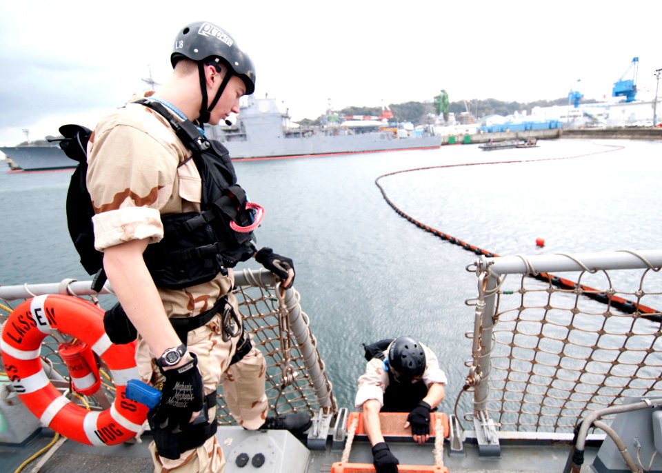 US Navy 100128-N-8721D-001 Air-Traffic Controller 3rd Class Vince Newell, left, prepares to disembark the guided-missile destroyer USS Lassen (DDG 82)