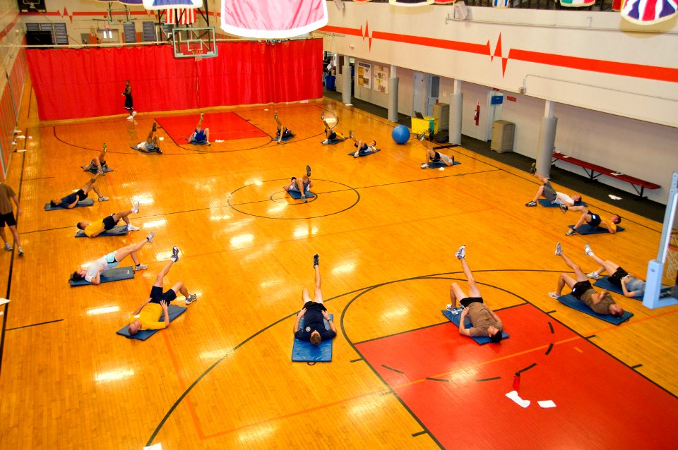 US Navy 100129-N-6674H-001 Mark McFarland, a fitness program coordinator for Navy Region Hawaii, leads Sailors in physical training as part of the Command Fitness Leader course