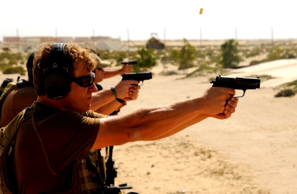 US Navy 100201-N-1291E-055 Explosive Ordnance Disposal Technician 2nd Class Robert Ganger, assigned to Explosive Ordnance Disposal Mobile Unit (EODMU) 11 fires his 9mm Pistol at a military shooting range in Bahrain