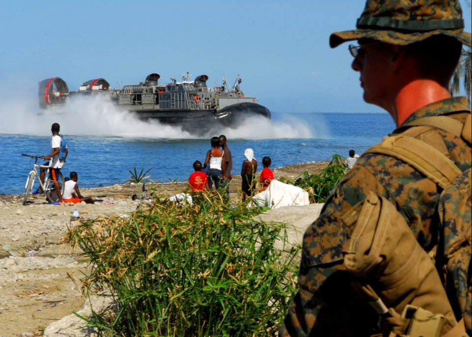 US Navy 100129-N-1092P-252 A Marine assigned to the 22nd Marine Expeditionary Force (22nd MEU) watches as a landing craft air cushion approaches the Grand-Goave, Haiti