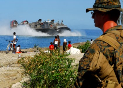 US Navy 100129-N-1092P-252 A Marine assigned to the 22nd Marine Expeditionary Force (22nd MEU) watches as a landing craft air cushion approaches the Grand-Goave, Haiti