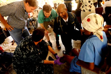 US Navy 100129-N-5345W-189 Lt. Cmdr. Jeffrey Lester, bottom left, a physician embarked aboard the multi-purpose amphibious assault ship USS Bataan (LHD 5), describes a Haitian woman's injuries to visiting members of Doctors Wit