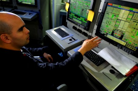 US Navy 100130-N-1688B-224 Gas Turbine Systems Technician (Mechanical) 1st Class Eli Miranda stands watch at the standard operating station unit during a damage control drill aboard the guided-missile cruiser USS Hue City (CG 6
