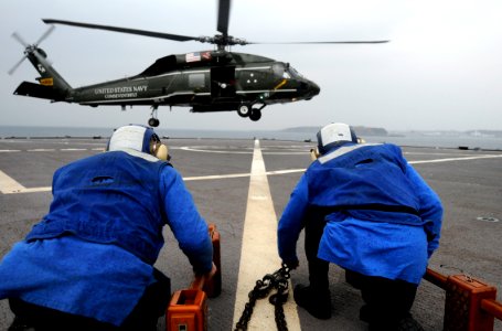US Navy 100201-N-7280V-444 Flight deck crew Sailors prepare to place chocks and chains on an SH-60F Sea Hawk helicopter during flight quarters aboard the U.S. 7th Fleet command ship USS Blue Ridge (LCC 19)