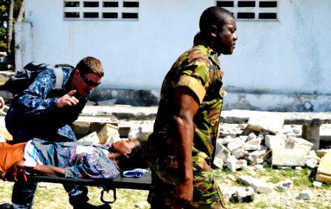 US Navy 100129-N-7948C-087 Logistics Specialist 3rd Class Jerdone McGhee, left, from Austin, Texas, speaks with a Haitian woman who is being medically evacuated