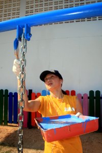 US Navy 100201-N-8960W-043 Hospital Corpsman 1st Class Angela Busscher, assigned to the aircraft carrier USS Nimitz (CVN 68), paints the playground at Baan Bang Thong primary school