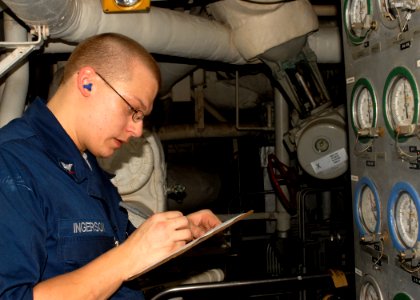 US Navy 100202-N-2000D-059 Engineman 3rd Class James Ingerson takes readings on an evaporator in main machinery room aboard the amphibious dock landing ship USS Carter Hall (LSD 50)
