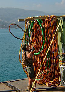 US Navy 100202-N-9643W-121 A member of Underwater Construction Team (UCT) 1 arranges hoses after completing work on a damaged pier at the main seaport of Port-au-Prince, Haiti photo