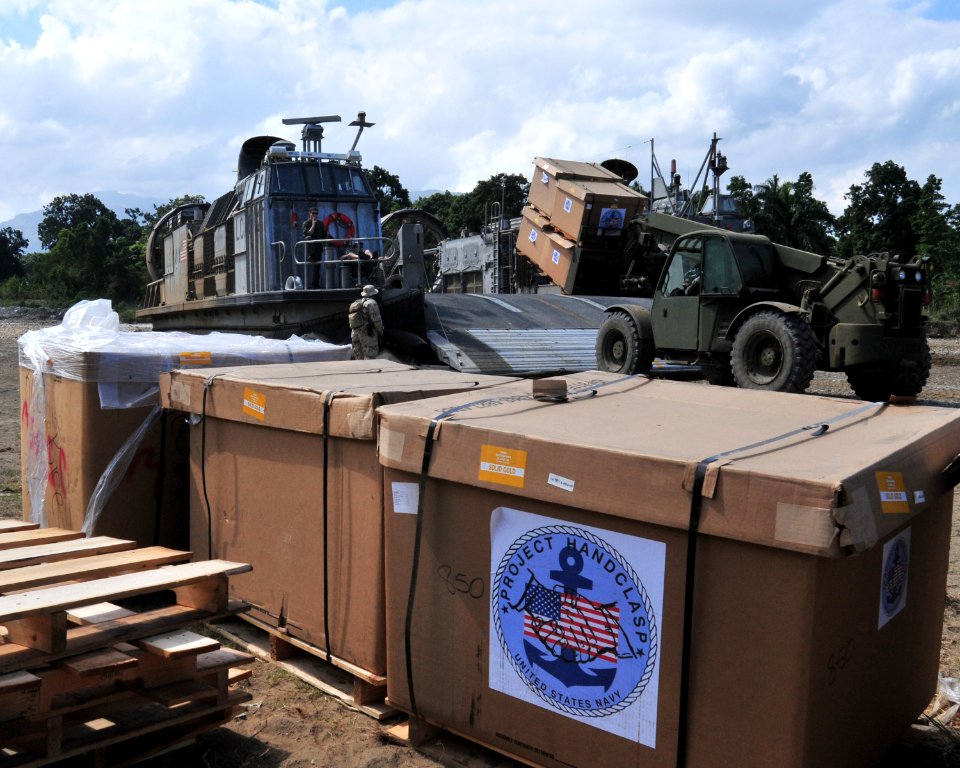 US Navy 100131-N-9740S-300 ailors from the amphibious assault ship USS Bataan (LHD 5) and Marines from the 22nd Marine Expeditionary Unit (22nd MEU) unload disaster relief supplies from an landing craft air cushion (LCAC) onto