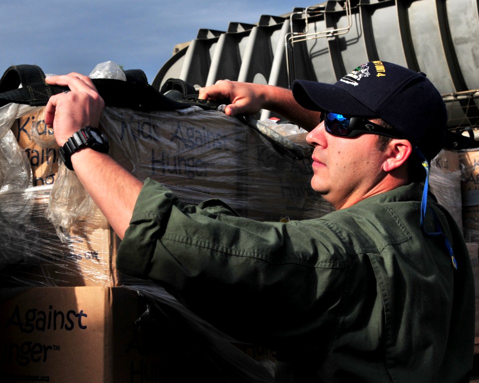 US Navy 100131-N-9740S-090 Operations Specialist 1st Class William Kitchens unloads relief supplies from a landing craft air cushion (LCAC) in Grand Goave, Haiti
