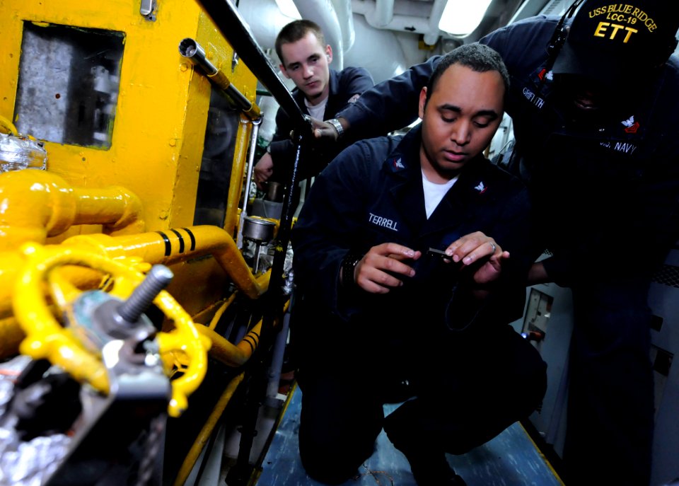 US Navy 100203-N-5716H-189 Machinist's Mate 1st Class Hensley Griffith evaluates Machinist's Mate 3rd Class Conley Terrell during an engineering training team drill aboard the U.S. 7th Fleet command ship USS Blue Ridge (LCC 19)