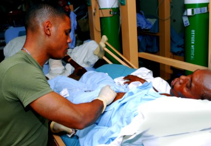 US Navy 100203-N-4047W-001 Hospitalman Christopher R. Brossard, assigned to the Military Sealift Command hospital ship USNS Comfort (T-AH 20), prepares to give a patient aboard Comfort a shot to prevent blood clotting