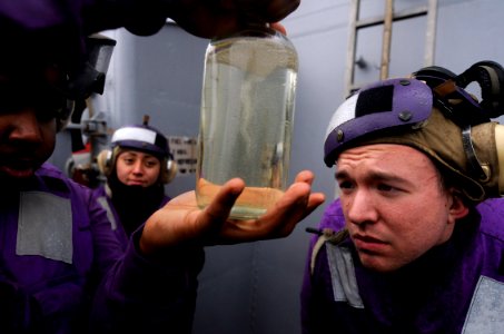 US Navy 100201-N-7280V-443 Engineman 2nd Class Victor Chavez tests JP-5 fuel for particles during flight quarters aboard the U.S. 7th Fleet command ship USS Blue Ridge (LCC 19)