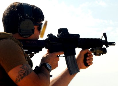 US Navy 100201-N-1291E-042 Explosive Ordnance Disposal Technician 2nd Class Christopher Ruley, assigned to Explosive Ordnance Disposal Mobile Unit (EODMU) 11, fires his M-4 rifle at a military shooting range in Bahrain photo