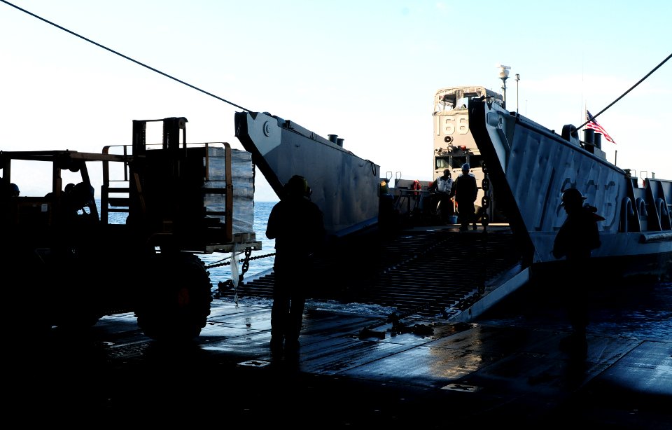 US Navy 100201-N-1831S-062 Sailors from Landing Craft Unit (LCU) 1663, assigned to Assault Craft Unit (ACU) 2, load supplies during a stern gate marriage with the amphibious assault ship USS Bataan (LHD 5)