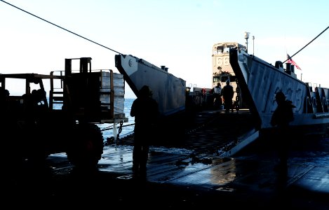 US Navy 100201-N-1831S-062 Sailors from Landing Craft Unit (LCU) 1663, assigned to Assault Craft Unit (ACU) 2, load supplies during a stern gate marriage with the amphibious assault ship USS Bataan (LHD 5)