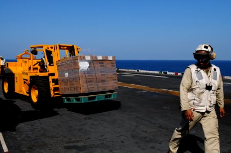 US Navy 100204-N-2735T-020 Sailors assigned to the combat cargo division aboard the amphibious assault ship USS Nassau (LHA 4) transport a pallet of meals-ready-to-eat for relief operations in Haiti