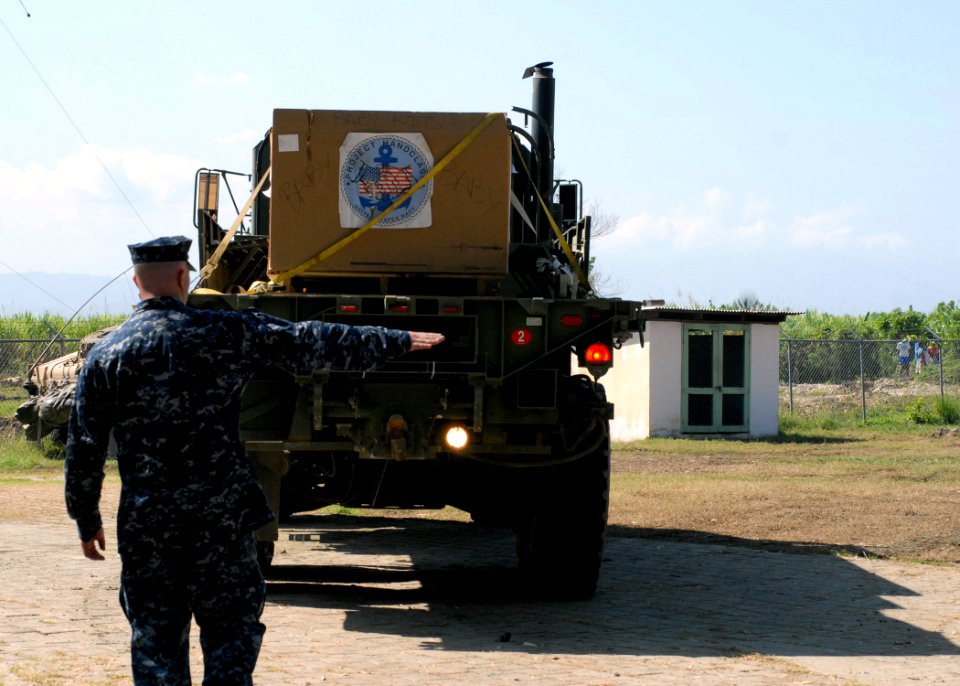 US Navy 100202-N-4971L-049 Sailor guides a cargo vehicle in Haiti