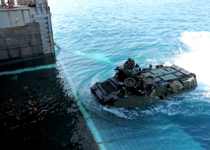US Navy 100202-N-6676S-004 Marines, assigned to the Marine Air-Ground Task Force for Africa Partnership Station West guide an amphibious assault vehicle into the well deck of the amphibious dock-landing ship USS Gunston Hall (L photo