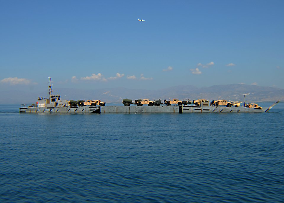 US Navy 100202-N-9643W-202 A causeway ferry from Amphibious Construction Battalion (ACB) 2 transports battalion construction vehicles and equipment to Port-au-Prince