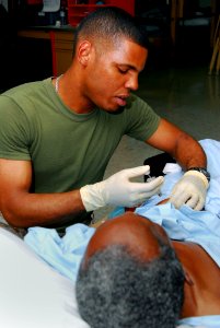 US Navy 100203-N-4047W-002 Hospitalman Christopher R. Brossard, assigned to the Military Sealift Command hospital ship USNS Comfort (T-AH 20), gives a patient aboard Comfort a shot to prevent blood clotting