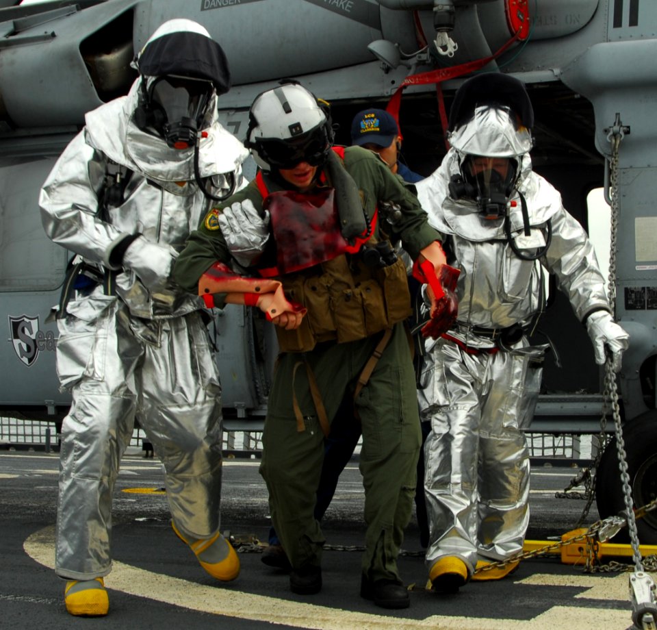 US Navy 100202-N-7058E-266 Flight-deck crewmen carry a simulated casualty away from an MH-60S Sea Hawk helicopter during an emergency landing drill aboard the littoral combat ship USS Freedom (LCS 1)