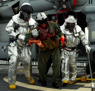 US Navy 100202-N-7058E-266 Flight-deck crewmen carry a simulated casualty away from an MH-60S Sea Hawk helicopter during an emergency landing drill aboard the littoral combat ship USS Freedom (LCS 1)