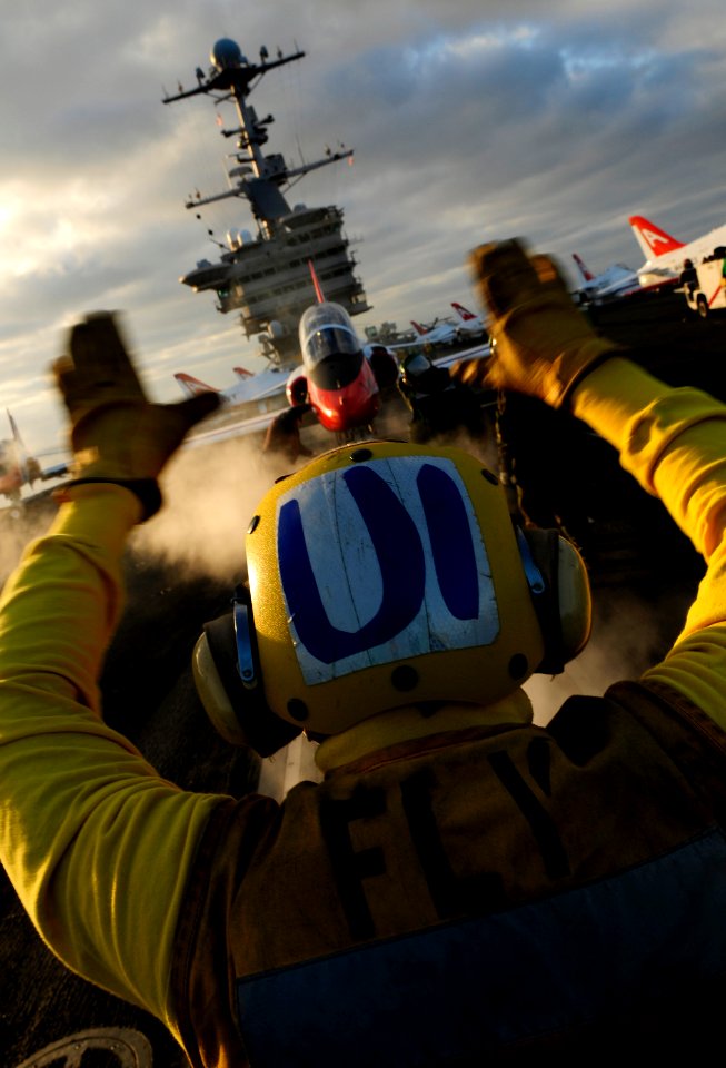 US Navy 100204-N-7780S-022 Aviation Boatswain's Mate (Handling) Airman Terrence Wever, from Charleston, S.C., directs a T-45C Goshawk from Training Wing 2 to a catapult aboard the Nimitz-class aircraft carrier USS John C. Stenn