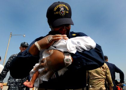 US Navy 100205-N-6676S-005 Chief Quartermaster Deenicia Canty holds a newborn baby at the Killick Haitian Coast Guard Base photo