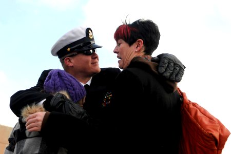 US Navy 100203-N-8467N-010 Chief Machinist's Mate John Graning hugs his wife and his 10 year-old daughter moments after the Los Angeles-class attack submarine USS Philadelphia (SSN 690) pulls into Submarine Base New London