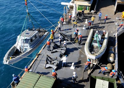 US Navy 100204-N-1082Z-017 Sailors assigned to the amphibious dock landing ship USS Ashland (LSD 48) lower a rigid hull inflatable boat into the water for Marines to aid relief efforts ashore