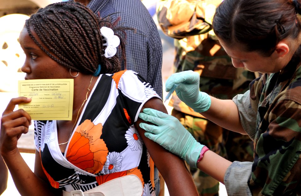 US Navy 100204-N-1831S-085 Hospital Corpsman 2nd Class Gina Martinez, a member of the U.S. Public Health Service, vaccinates a Haitian woman