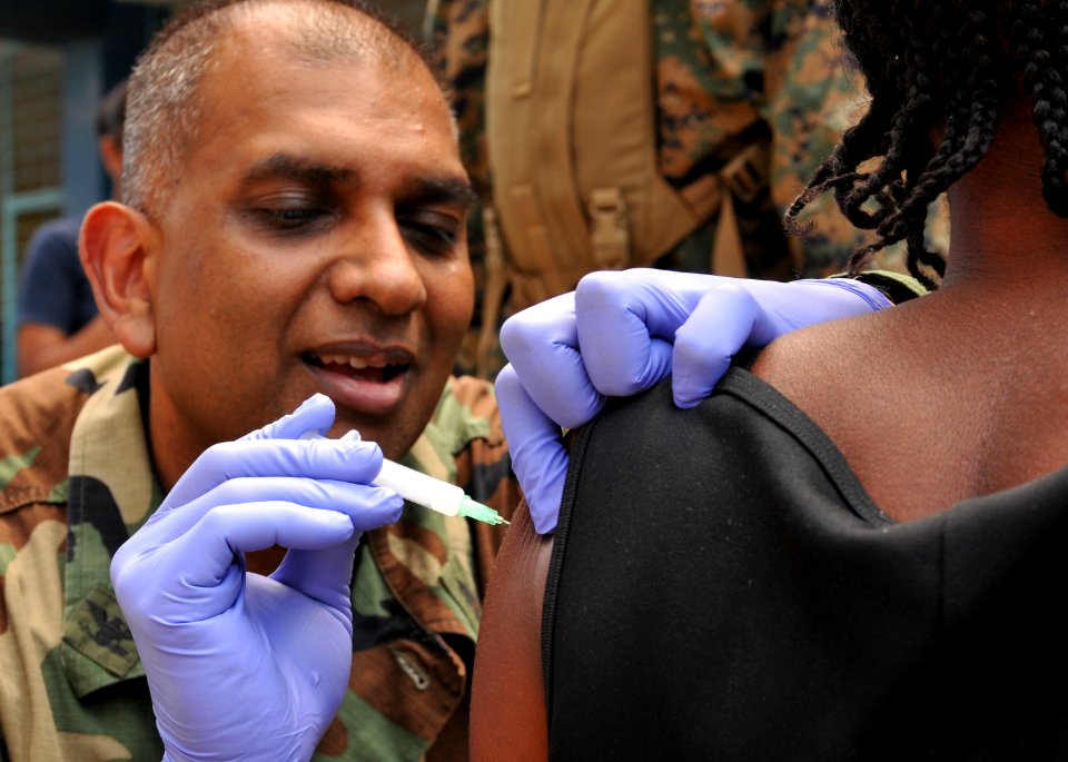 US Navy 100204-N-1831S-348 Capt. Nalan Narine, a member of U.S. Public Health Service, vaccinates a Haitian woman