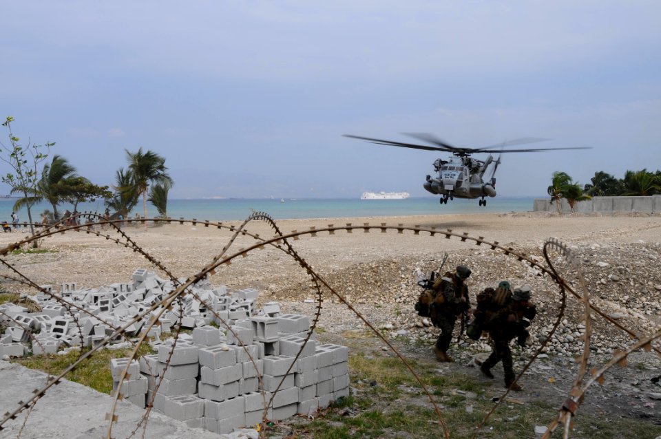 US Navy 100206-N-2735T-038 arines from the 22nd Marine Expedition Unit (22nd MEU) carry supplies from an CH-53E Sea Stallion helicopter after arriving at the Civilian Military Operations Center in Carrefour, Haiti