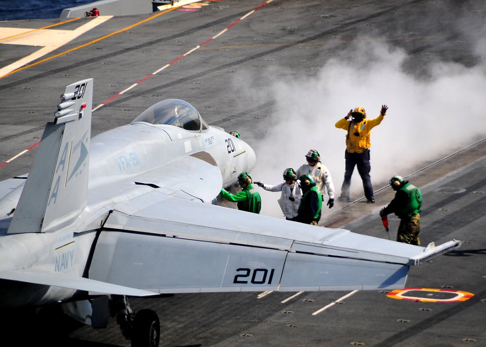 US Navy 100204-N-4774B-368 Flight deck control members aboard the Nimitz-class aircraft carrier USS Carl Vinson (CVN 70) direct an F-A-18 Super Hornet assigned to the Sunliners of Strike Fighter Squadron (VFA) 81