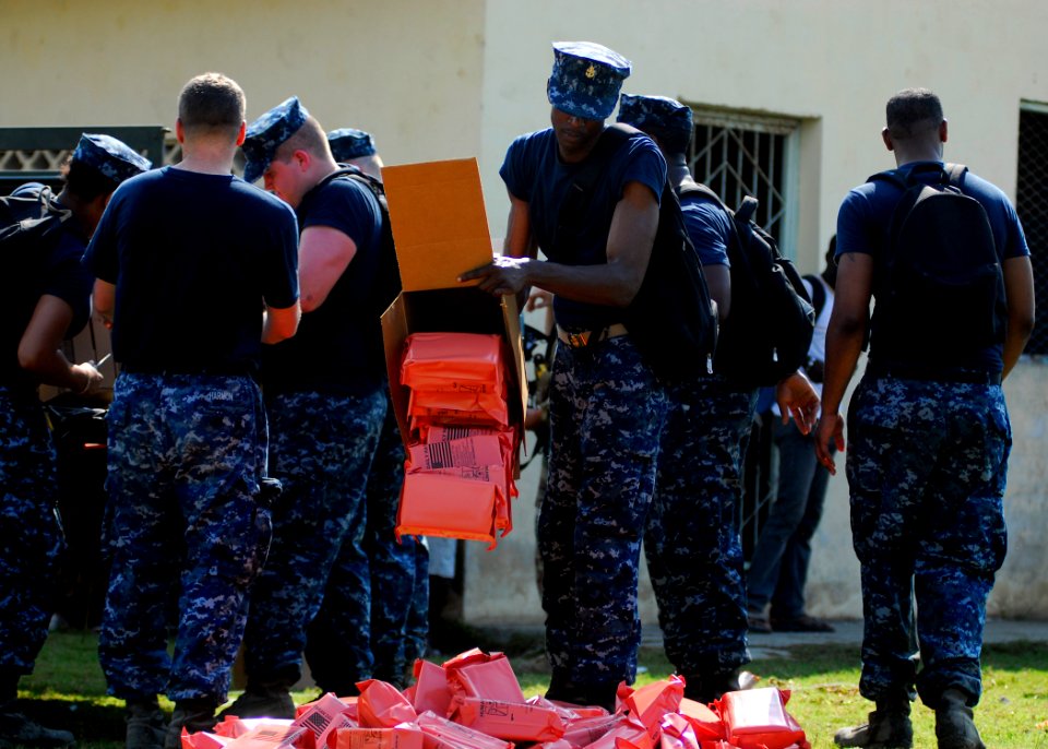 US Navy 100204-N-5244H-046 ailors assigned to the amphibious dock landing ship USS Carter Hall (LSD 50) prepare to distribute food at an aid distribution center