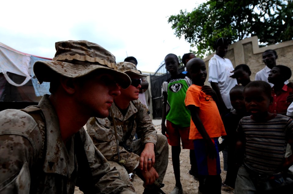 US Navy 100206-N-2735T-266 Lance Cpl. Joseph Marsh and Lance Cpl. Aaron Adkins peak with earthquake survivors during a reconnaissance patrol