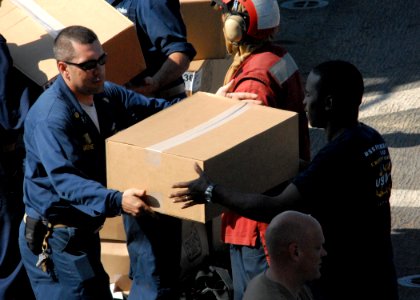 US Navy 100206-N-4971L-066 Sailors and Marines onload stores and relief supplies aboard the amphibious dock landing ship USS Fort McHenry (LSD 43)