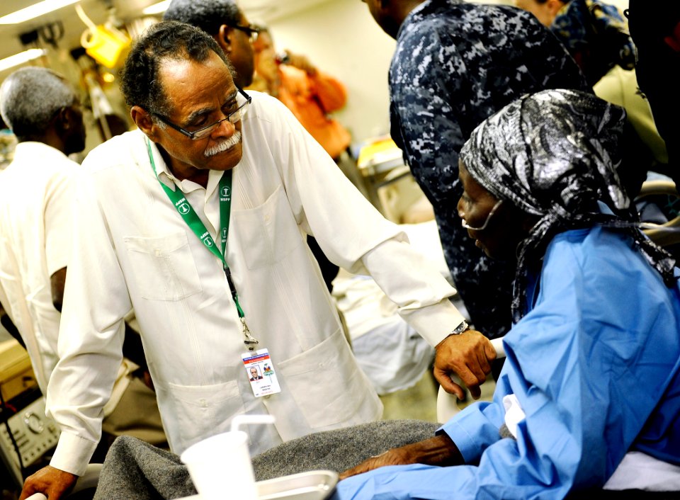 US Navy 100206-N-5345W-127 Dr. Alex Larsen, the Minister of Public Health in Haiti, speaks with a Haitian patient in the medical ward aboard the amphibious assault ship USS Bataan (LHD 5)