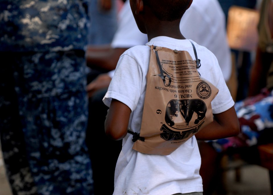 US Navy 100207-N-2000D-001 A Haitian boy uses a meal-ready-to-eat bag as a backpack in Neply, Haiti