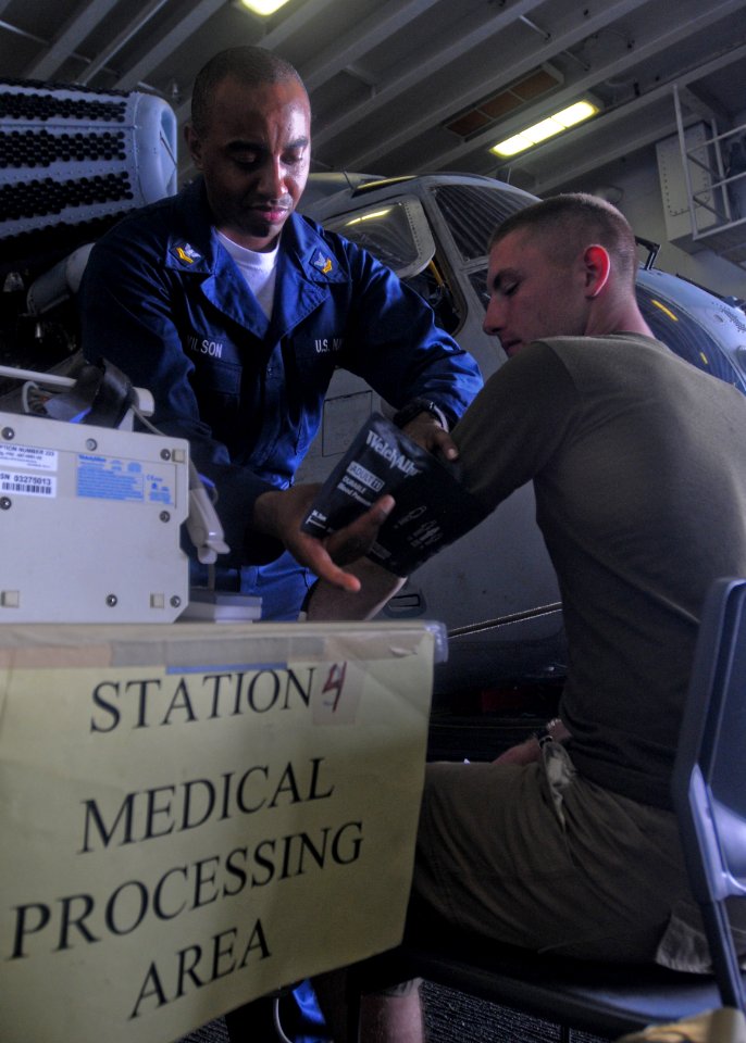 US Navy 100206-N-9950J-288 Hospital Corpsmen 2nd Class Emilio Wilson takes the blood pressure of an evacuee during a non-combatant evacuee operation drill aboard the forward-deployed amphibious assault ship USS Essex (LHD 2)