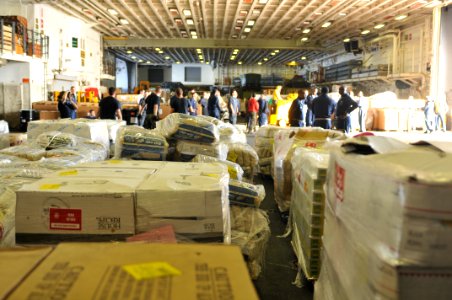 US Navy 100205-N-1831S-150 Sailors bring relief supplies into the hangar bay aboard the amphibious assault ship USS Bataan (LHD 5)