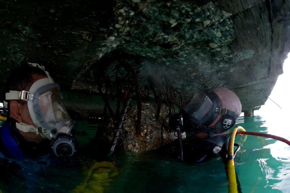 US Navy 100205-N-1134L-124 Steelworker 1st Class William Butcher, assigned to Underwater Construction Team (UCT) 1, drills guide holes into a damaged section of a pier at the port in Port-au-Prince, Haiti